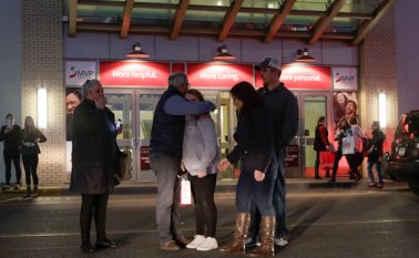 Gente abrazándose tras salir del Crossgates Mall en Guilderland, Nueva York, tras un tiroteo en el interior del centro comercial, este sábado. Más de 100 agente con rifles de asalto se desplegaron en el lugar. AP