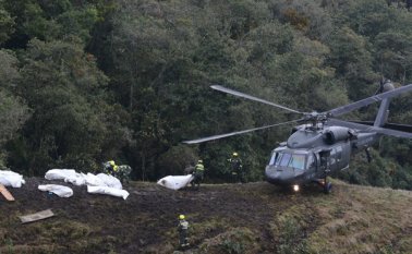 Rescatistas cargan en un helicóptero los cuerpos de las víctimas de la caída de un avión cerca de Medellín. AP