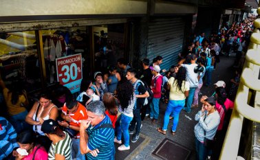 Personas hacen cola comprar en la empresa EPK, en Caracas, el 22 de diciembre de 2016.
AFP