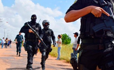 Policías fuertemente armados caminan fuera de la Penitenciaría Agrícola de Monte Cristo, luego de que decenas de reclusos fueran asesinados. AP