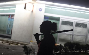 Las detenciones por los saqueos y actos vandálicos en más de 300 establecimientos en distintos puntos del país llegaron al millar de personas. En la gráfica, una mujer sostiene un palo mientras ella y otros vecinos buscan evitar saqueos en la ciudad portuaria de Veracruz. AP