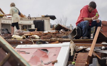 Jeff Bullard permanece sentado en lo que solía ser la sala de su casa mientras su hija, Jenny Bullard, recorre los escombros de la vivienda que fue destruida por un tornado en Adel, Georgia. El gobernador Nathan Deal declaró el estado de emergencia en diversos condados, entre ellos el de Cook. AP