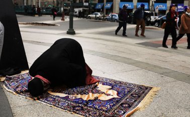 Un hombre musulmán ora en la calle antes del comienzo de una protesta contra las políticas de inmigración del presidente Donald Trump. AFP