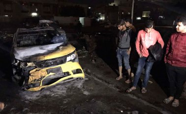 Unas personas observan la zona donde un coche bomba explotó en el vecindario Al-Bayaa, de Bagdad, la capital iraquí, dejando decenas de muertos y heridos. AP