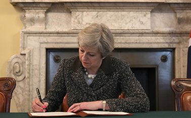 Theresa May, primera ministra británica, firma la carta que ratifica la activación del brexit.  AFP