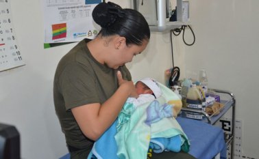 Alejandra Gutiérrez, en uniforme, alimenta a dos de los bebés refugiados en los albergues en Mocoa. Minutos antes estaba actuando como la policía que es. Cortesía