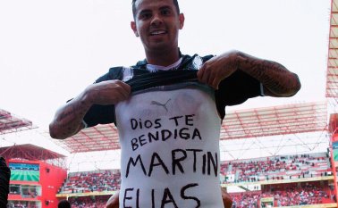 Cardona se levantó la camisa para mostrar el mensaje que tenía en su otra franela. Tomada de Twitter