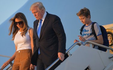 Melania y Barron descendieron las escaleras del avión presidencial al lado de Trump. AFP