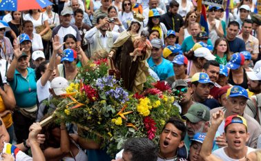 Varias mujeres caminaban con cruces de flores de colores; otras sostenían rosarios o carteles con letras que formaban la frase: "Basta de división, queremos lo mismo". AFP