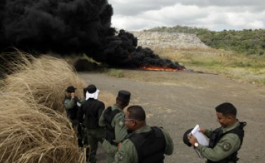 Agentes de la Policía observan la incineración del alijo de drogas incautado en Ciudad de Panamá. En el recuadro, paquetes de cocaína y píldoras de efedrina y metanfetamina que hacían parte del cargamento incautado.