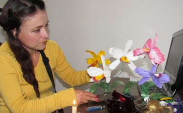Jessica Acosta Angarita le da forma y color al plástico formando orquídeas, margaritas y rosas. Roberto Ospino