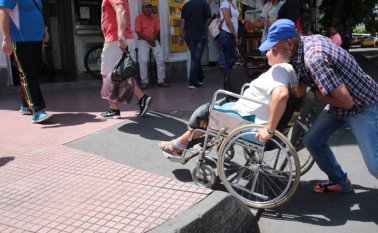 Los transeúntes ayudan a Marlene Gómez a subir a los andenes por las rampas que se construyeron en el centro, pues la pendiente de inclinación no le permite hacerlo por sus propios medios en su silla de ruedas. César Obando