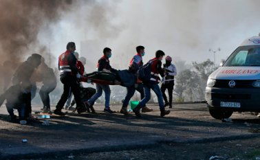 Manifestantes palestinos llevan a un herido durante enfrentamientos con tropas israelíes cerca de un puesto de control israelí en la ciudad de Ramallah, Cisjordania. AFP