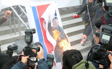Manifestantes en Seúl quemaron una imagen del dirigente norcoreano Kim Jong-Un y la bandera de Corea del Norte, en el momento en el que se celebraba la visita de una delegación del país. AFP