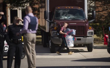 Un estudiante de la Central Michigan University pasa junto a la policía con sus pertenencias cuando abandona Campbell Hall, donde tuvo lugar un tiroteo este viernes. AFP