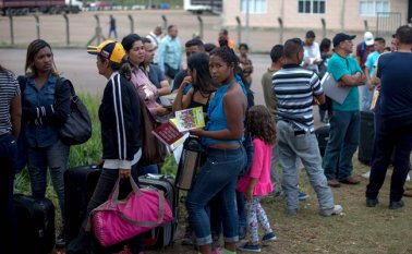 Esta imagen tomada el 28 de febrero muestra a venezolanos en una fila frente a la Oficina de la Policía Federal de Brasil, en Roraima. Al menos 50 mil venezolanos han llegado por vía terrestre al ese estado. AFP