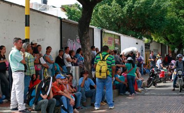 Las casas de giros atienden a un promedio de 300 personas diariamente. Estos usuarios deben esperar en andenes y en parques. Mario Caicedo / La Opinión