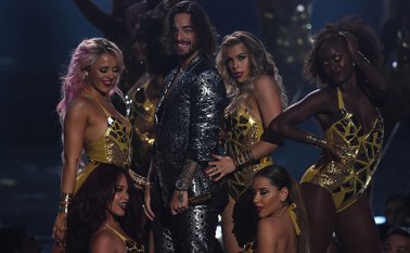 Ataviado con un traje plateado sin camisa debajo y acompañado de un atractivo cuerpo de bailarinas junto al que se contoneó de forma muy sensual. AFP