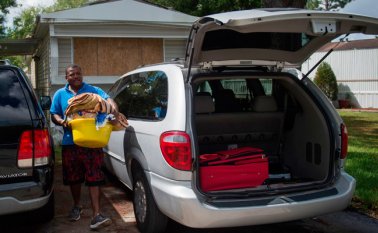 Las familias luego de poner láminas para proteger la estructura de sus casas, se marchan a lugares seguros para proteger sus vidas. AFP
