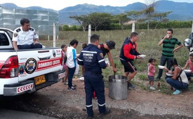 Los apagafuegos le dieron alimentación a los migrantes que huyen de Venezuela caminando desde Cúcuta a Bucaramanga. Cortesía