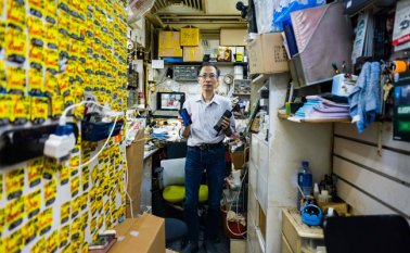 En esta foto tomada el 7 de noviembre de 2018, el experto en reparaciones de celulares Wilson Wong posa con un viejo modelo de iPhone 7, en su tienda en Hong Kong. Cada iPhone emite entre 54 y 110 kg de CO2 durante su fase de construcción, según Apple. AFP