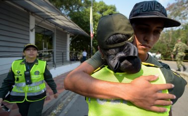 Un policía colombiano abraza a un miembro de las Fuerzas Armadas de Venezuela que desertó a este país. AFP