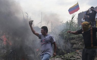 El medio estadounidense muestra cómo una persona opositora al gobierno de Nicolás Maduro lanza una bomba molotov.  Colprensa