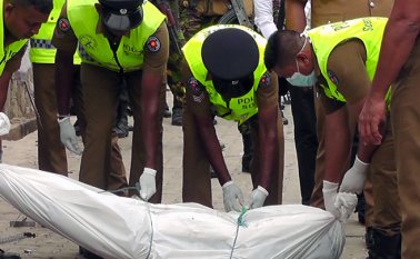 Los policías se preparan para retirar el cuerpo de unos los terroristas abatidos en Kalmunai. AFP