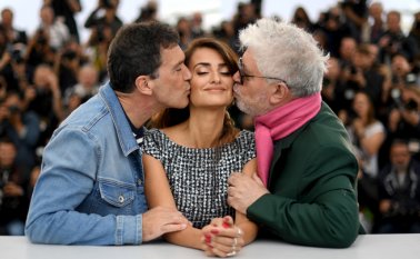 Almodóvar posó con traje verde y bufanda rosa, junto a Cruz, vestida con un vestido blanco y negro con pliegues en la falda, y Banderas, con cazadora y suéter de rayas azules y blancas. AFP