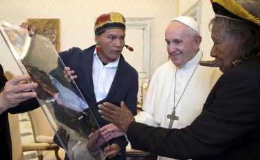 El papa francisco intercambió obsequios con el legendario líder indígena Raoni, a quien recibió ayer en el Vaticano. AFP