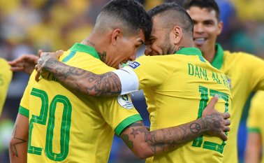 Dani Alves celebra con su compañero Roberto Firmino luego de anotar contra Perú. AFP