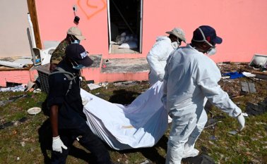 La policía y los miembros de un equipo de recuperación sacan a una víctima en Marsh Harbour, Bahamas, el 10 de septiembre, una semana después del huracán Dorian.  AFP