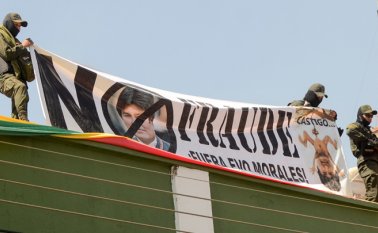 Policías en rebelión sostienen una pancarta con fotos del presidente de Bolivia, Evo Morales, y leen "¡No al fraude, Evo Morales fuera!".
AFP
