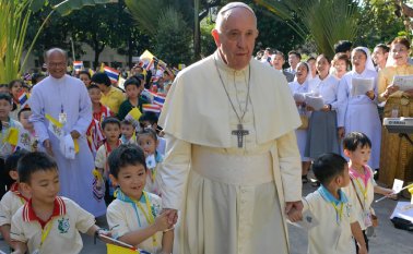 El papa Francisco camina con niños, mientras se prepara para abordar su avión para partir, este sábado, desde el aeropuerto militar de Bangkok, Tailandia, hacia a Japón AFP