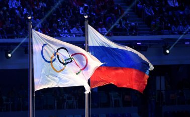 Esta foto de archivo muestra la bandera olímpica y la bandera rusa ondeando durante la Ceremonia de Clausura de los Juegos Olímpicos de Invierno de Sochi en el Estadio Olímpico Fisht. Archivo