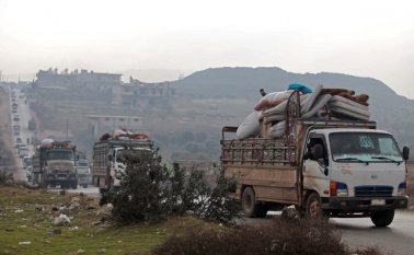 Familias huyen de Idlib hacia la frontera sirio-turca. AFP