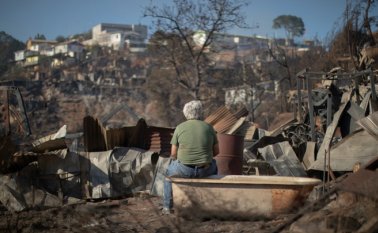 Un hombre observa la destrucción causada por un incendio forestal en el cerro Rocuant, en Valparaíso, Chile, este 25 de diciembre. AFP
