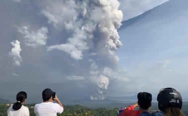 La gente toma fotos tras una explosión freática del volcán Taal. Vista desde la ciudad Tagaytay, en la provincia de Cavite. La última erupción del Taal data de 1977. AFP