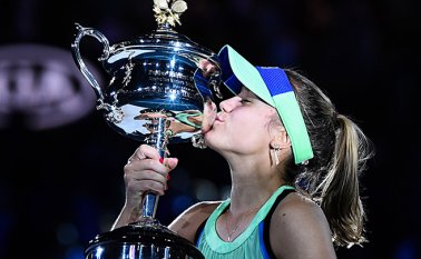 Sofía Kenin besa la Daphne Akhurst Memorial Cup después de ganar contra la española Garbine Muguruza en la final del Abierto de Australia. AFP
