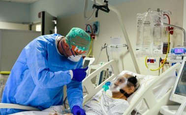 Un médico consuela a un paciente infectado por el nuevo coronavirus en la división COVID-19 del hospital ASST Papa Giovanni XXIII en Bérgamo, Itaia. AFP