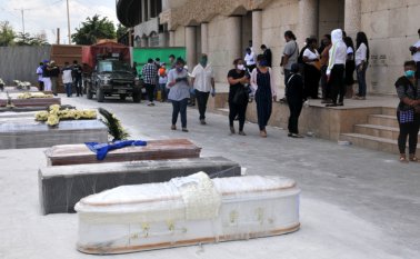 La gente espera junto a los ataúdes para enterrar a sus seres queridos afuera de un cementerio en Guayaquil, Ecuador. Un número creciente de muertes por COVID-19 en la segunda ciudad ecuatoriana ha provocado una escasez de ataúdes, lo que ha obligado a los locales a recurrir al uso cajas de cartón, dijeron las autoridades de la ciudad el domingo. AFP