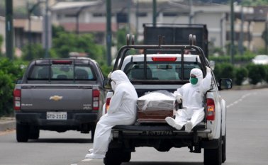 Personas con trajes protectores acompañan a un ataúd en un camión cerca del hospital Los Ceibos en Guayaquil, Ecuador, el 8 de abril de 2020, en medio del nuevo brote de coronavirus.
 AFP