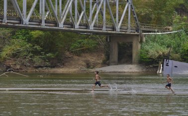 El otrora caudaloso río Catatumbo hoy luce débil y cansado, al punto de que dos niños 'corren' sobre sus aguas luego de atravesarlo sin inmutarse.  Colprensa