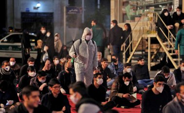 Los iraníes, algunos con máscaras faciales contra el coronavirus COVID-19, asisten a las oraciones de Laylat al-Qadr, una de las noches más santas durante el mes de ayuno musulmán del Ramadán, frente a una mezquita en Teherán
AFP