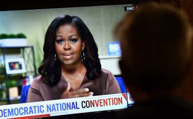 Una persona observa a la ex primera dama Michelle Obama hablar durante la noche de apertura de la Convención Nacional Demócrata, la noche del lunes. AFP