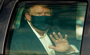Trump saluda a simpatizantes desde su auto. AFP