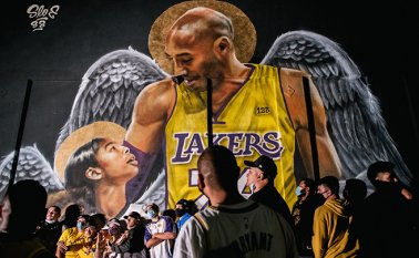 Los fanáticos de los Lakers hacen fila para celebrar frente a un mural de Kobe Bryant y su hija Gianna Bryant. AFP