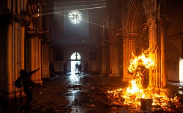 Incendio provocado por manifestantes dentro de la iglesia San Francisco de Borja, en Santiago, durante enfrentamientos con la policía antidisturbios, en la conmemoración del primer aniversario del levantamiento social en Chile. AFP