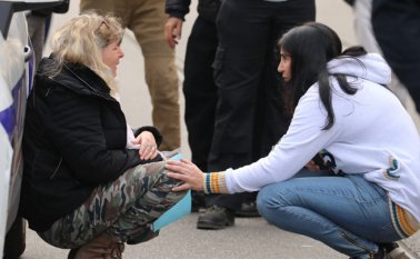 Una mujer se arrodilla junto a un carro de la Policía mientras llora, después de un ataque con cuchillo en Niza. AFP