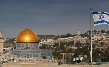 Una bandera israelí ondea en el techo de un edificio en la ciudad vieja de Jerusalén frente a la Cúpula de la Roca (centro) en el recinto de la mezquita Al-Aqsa. Archivo